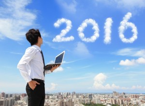 Young business man using laptop and look to 2016 year text with blue sky and cloud and cityscape in the background, asian