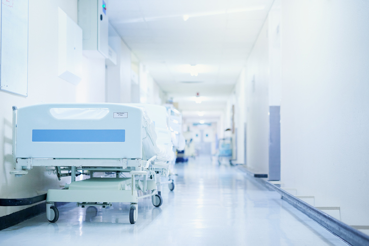 Shot of a hospital bed in an empty corridor of a modern hospital. The Nurse Staffing Shortage can be problematic.